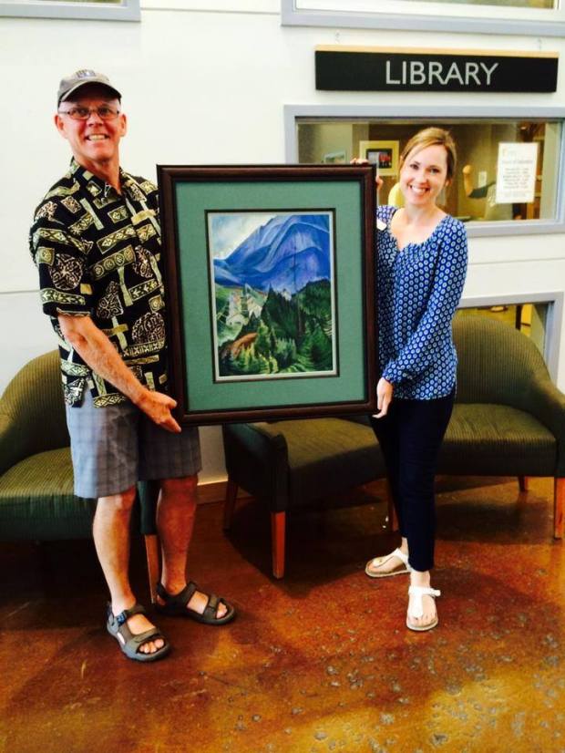Dave Perfitt donates a print of Emily Carr's "Pemberton Meadows" to the Pemberton Library.